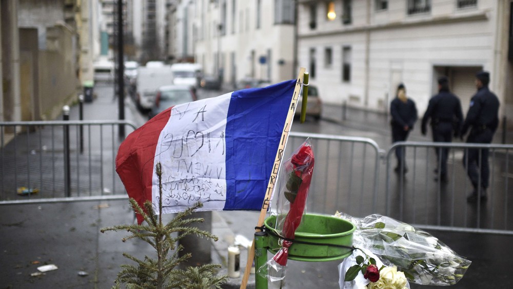 A French flag reading "to Liberty" is placed near a barrier outside the offices of French satirical newspaper Charlie Hebdo in Paris on Jan. 8, 2015.