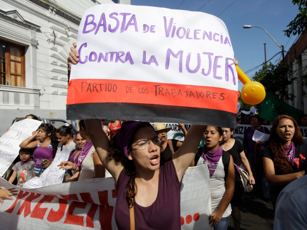 International Women's Day in Asuncion, Paraguay, Friday, March 8, 2013. The poster reads in Spanish "Enough violence against women." (Photo by Jorge Saenz/AP Photo)