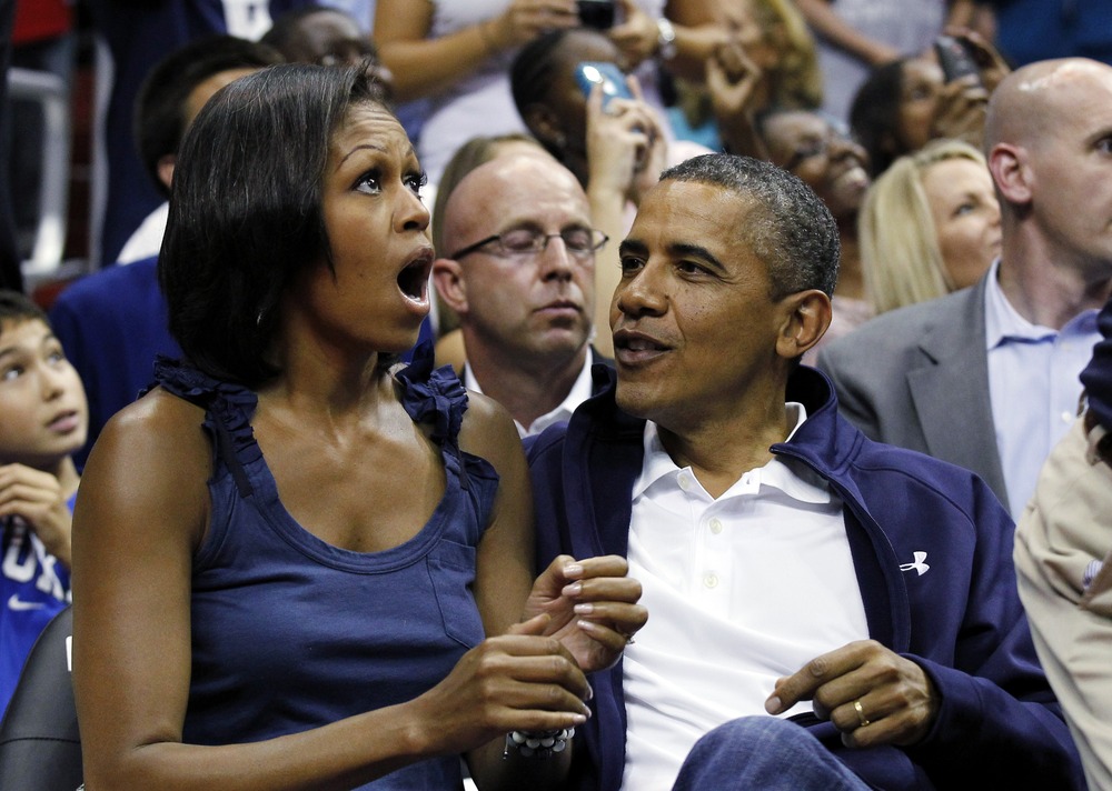 President Barack Obama and first lady Michelle Obama look up at themselves on the large in-house video screen as they appear on "Kiss Cam'.