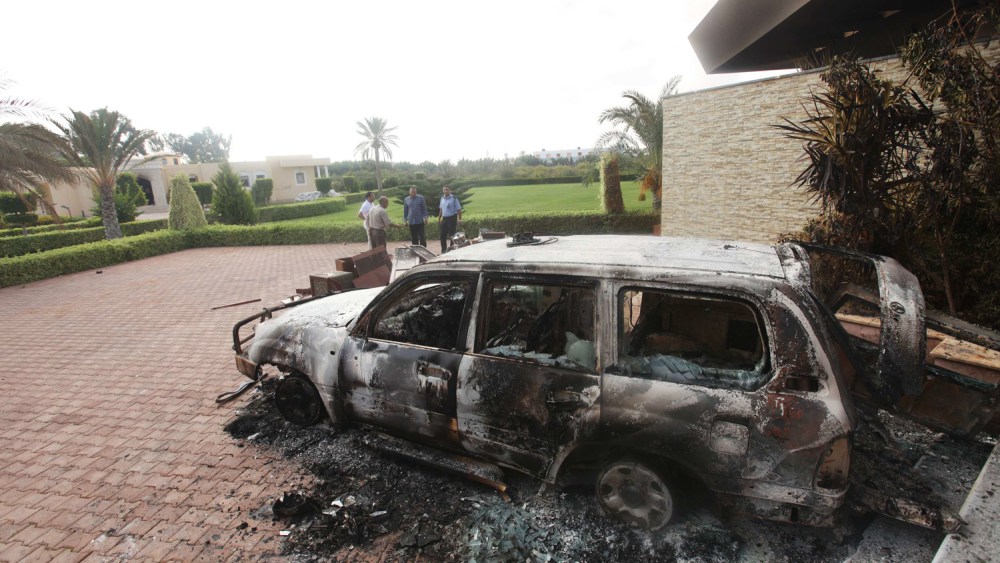 PHOTOBLOG: People stand near a burnt car at the U.S. consulate in Benghazi, Libya.