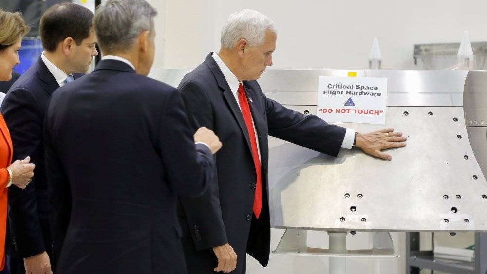 Image: U.S. Vice President Mike Pence touches a piece of hardware with a warning label "Do Not Touch" at Kennedy Space Center in Florida