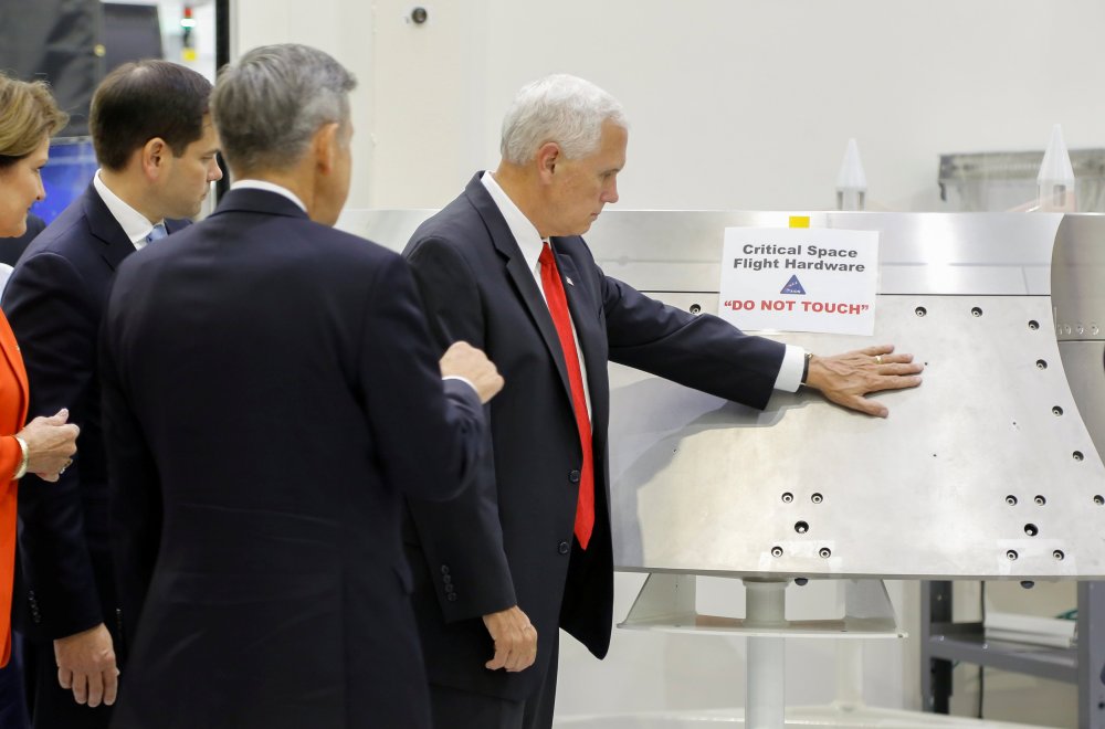 Image: U.S. Vice President Mike Pence touches a piece of hardware with a warning label "Do Not Touch" at Kennedy Space Center in Florida