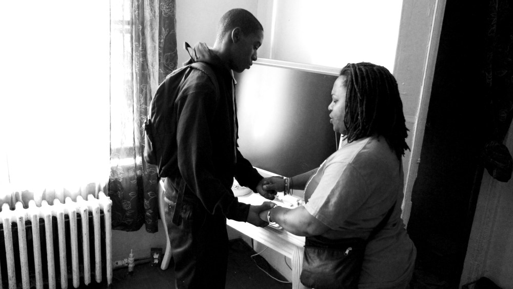 Khyrie Hawkins, 13, and his mother Dawn Hawkins pray in their Philadelphia home