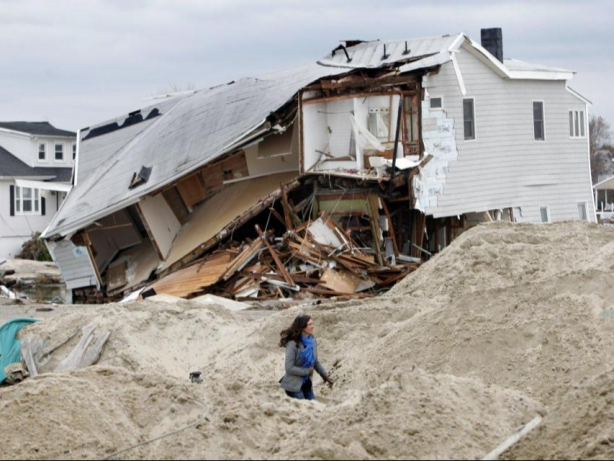 Sea Bright Mayor Dina Long walks along Ocean Avenue past a destroyed house that was knocked off its foundation during Hurricane Sandy, as seen on November 1, 2012 in Sea Bright, New Jersey. (Photo by Aristide Economopoulos/The Star-Ledger via Corbis)