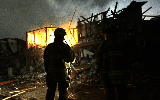 Firefighters use flashlights to search a destroyed apartment complex near a fertilizer plant that exploded earlier in West, Texas, in this photo made early Thursday morning, April 18, 2013.  (AP Photo/LM Otero)