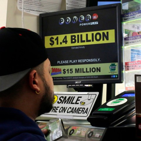A man buys Powerball tickets at a convenience store in Lancaster, Pa., Jan. 11, 2016. (Photo by Gene J. Puskar/AP)