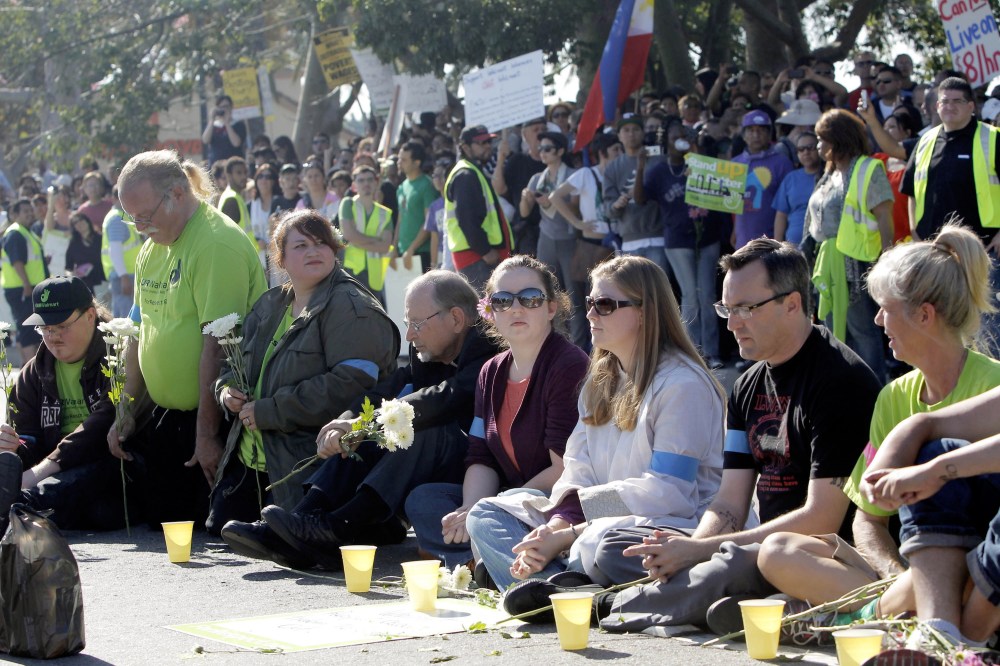 Protestors sit outside the Walmart store Friday Nov. 23, 2012 in Paramount, Calif. Wal-Mart employees and union supporters are taking part in today's nationwide demonstration for better pay and benefits A union-backed group called OUR Walmart, which...