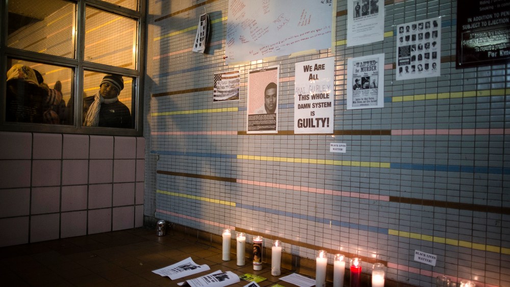 A demonstrator looks on a memorial to Akai Gurley who was shot to death by rookie NYPD officer Peter Liang at the Louis Pink Houses public housing complex on Nov. 22, 2014, in the Brooklyn borough of New York.