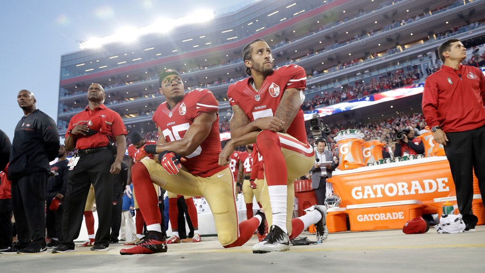 San Francisco 49ers safety Eric Reid (35) and quarterback Colin Kaepernick (7) kneel during the national anthem before an NFL football game against the Los Angeles Rams, Sept. 12, 2016, in Santa Clara, Calif. (Photo by Marcio Jose Sanchez/AP)