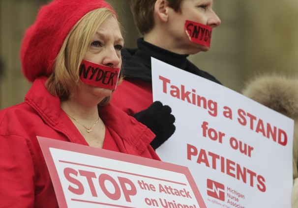 Debbie Nault of the Michigan Nurses Association stands with fellow members of the association on the Capitol steps in Lansing, Mich. (Photo by Carlos Osorio / AP)