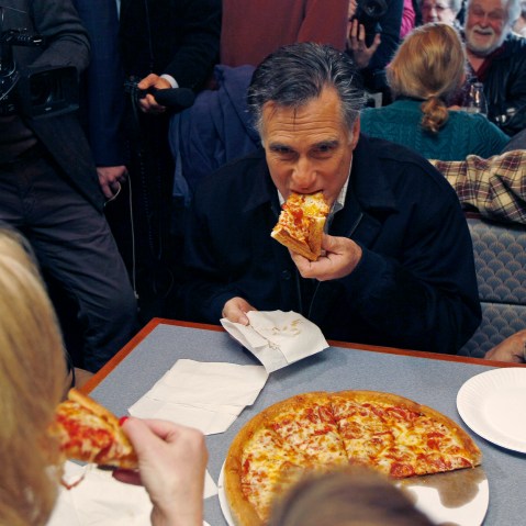 Republican presidential candidate former Mass. Gov. Mitt Romney takes a bite of pizza during lunch with his wife Ann while campaigning at Village Pizza in Newport, N.H., Wednesday Dec. 20, 2011. (AP Photo/Charles Krupa)