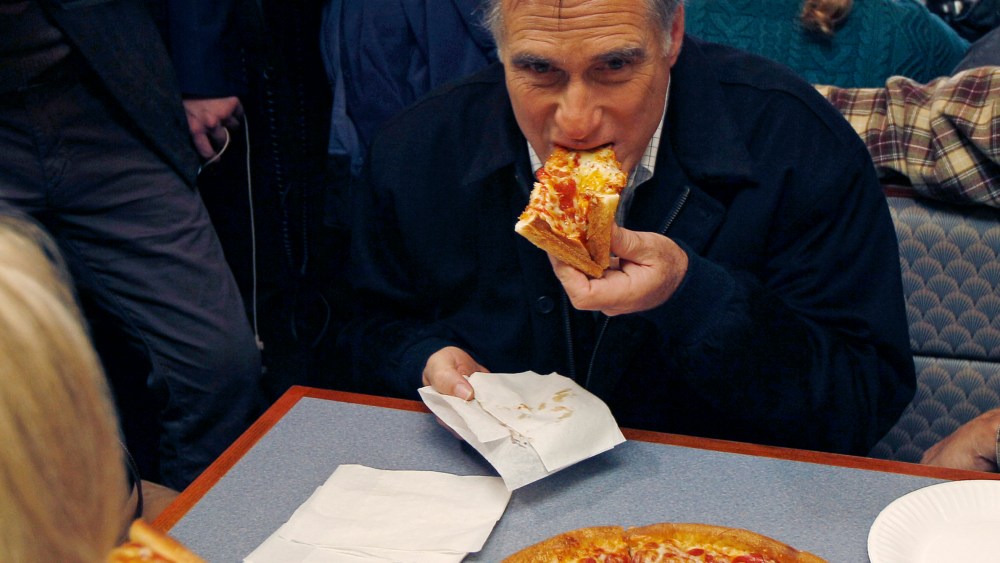 Republican presidential candidate former Mass. Gov. Mitt Romney takes a bite of pizza during lunch with his wife Ann while campaigning at Village Pizza in Newport, N.H., Wednesday Dec. 20, 2011. (AP Photo/Charles Krupa)