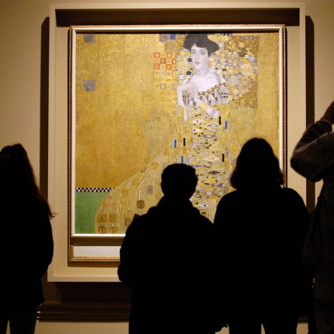 Museum visitors study 1907 painting by Austrian artist Gustav Klimt in Los Angeles