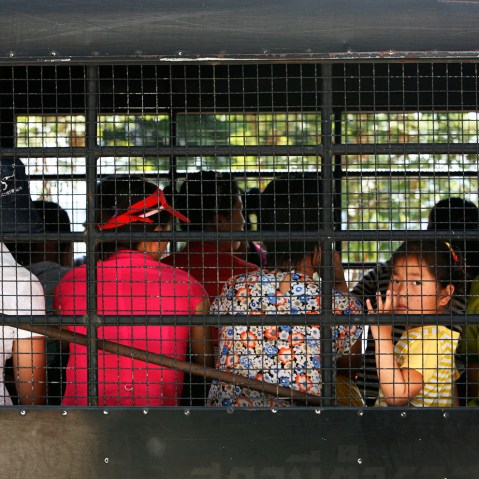 A young girl looks out as group of asylum seekers depart for a courthouse from the Chiang Saen police station in Thailand's Chiang Rai province.