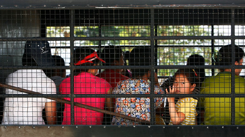 A young girl looks out as group of asylum seekers depart for a courthouse from the Chiang Saen police station in Thailand's Chiang Rai province.