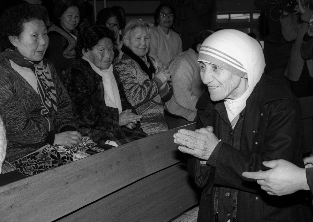 Mother Teresa is welcomed by aged women lepers on arriving at St. Lazarus Leprosy Village's church in Shinhung, Korea