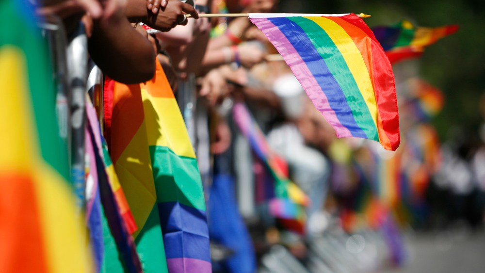 The sidewalks are filled with rainbow flags as revelers celebrate Gay Pride.