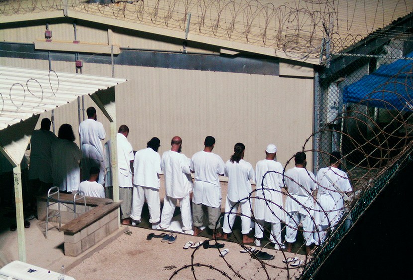 Detainees participate in an early morning prayer session at Camp IV at the detention facility in Guantanamo Bay U.S. Naval Base August 5, 2009. (Photo by Deborah Gembara/Reuters)