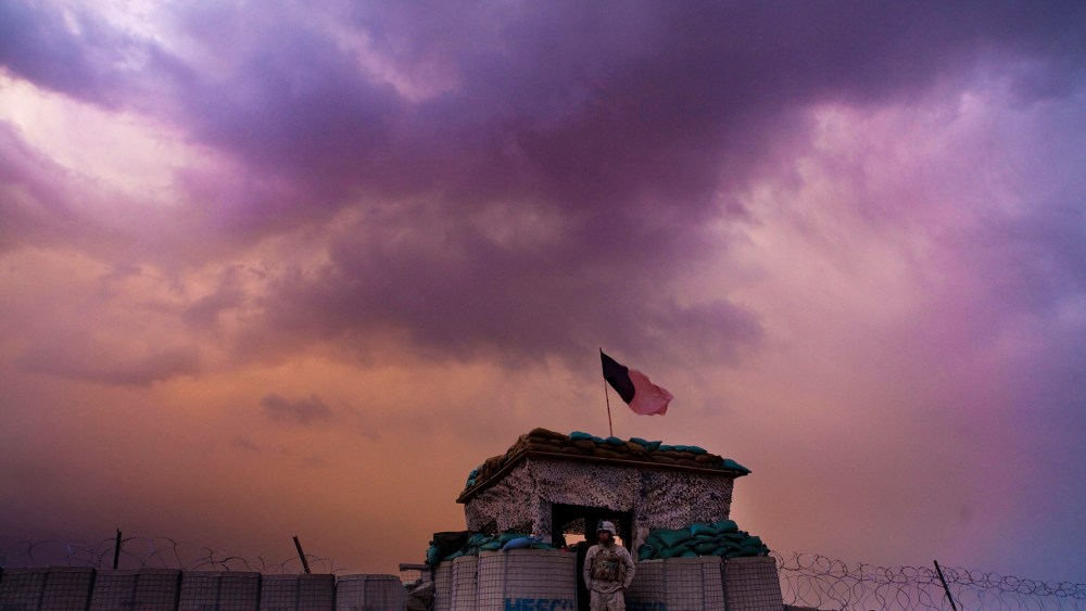 A U.S. Marine from the First Battalion Eighth Marines Alpha Company looks out as an evening storm gathers above an outpost near Kunjak in southern Afghanistan's Helmand province, Feb. 22, 2011. (Photo by Finbarr O'Reilly/Reuters)