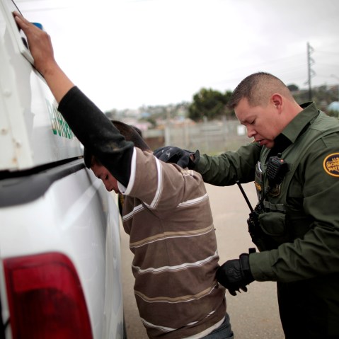 A United States border patrol agent catches an undocumented immigrant crossing from Mexico to the U.S. in San Ysidro