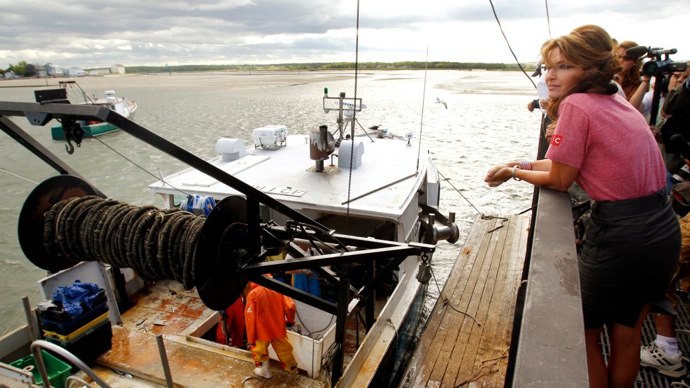 Former Alaska Governor Palin watches a fishing boat unload its catch during a visit to Yankee Seafood Cooperative in Seabrook