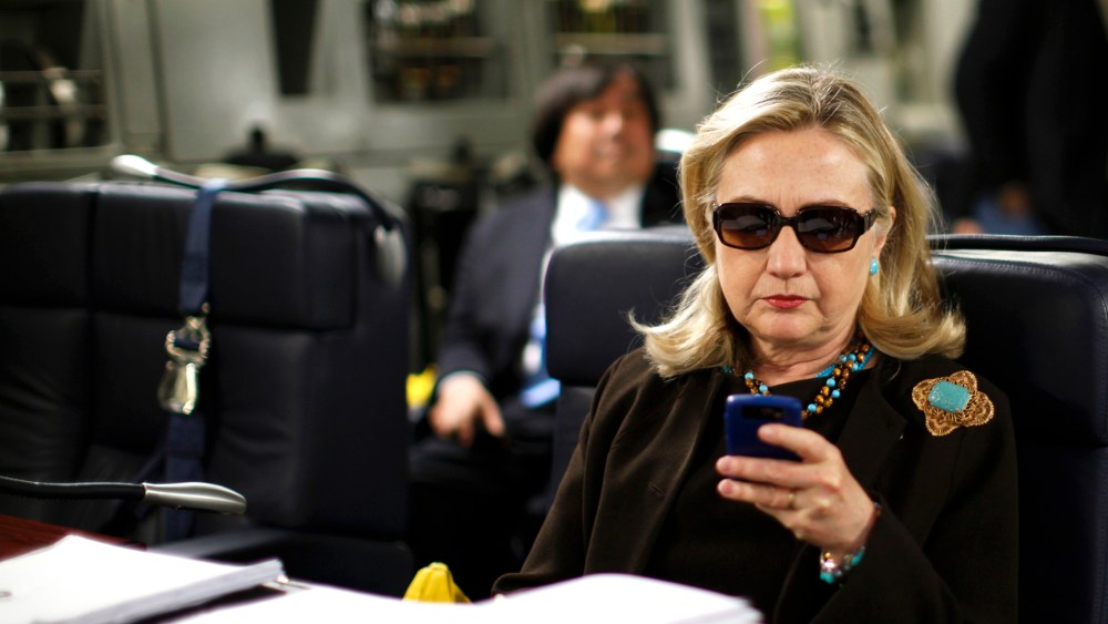 Secretary of State Hillary Clinton checks her phone upon her departure in a military plane from Malta bound for Tripoli, Libya on Oct. 18, 2011. (Photo by Kevin Lamarque/Reuters)