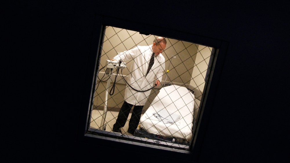 Dr. William Sullivan, a physician at the University of Illinois at Chicago hospital, is seen through a re-enforced window of a psychiatric evaluation room, Dec. 21, 2011.
