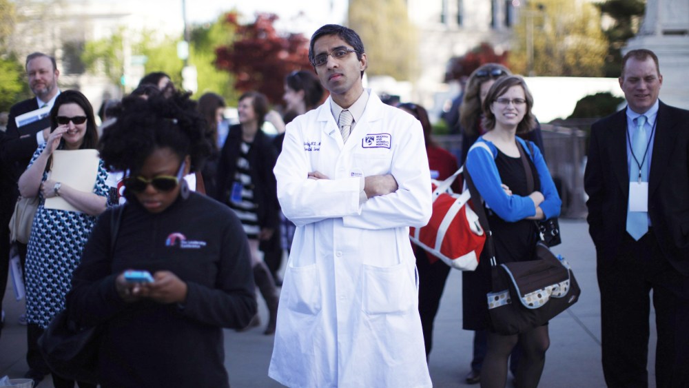 Doctor Vivek Murthy stands among other bystanders during the first day of legal arguments over the Affordable Care Act outside the Supreme Court in Washington March 26, 2012.