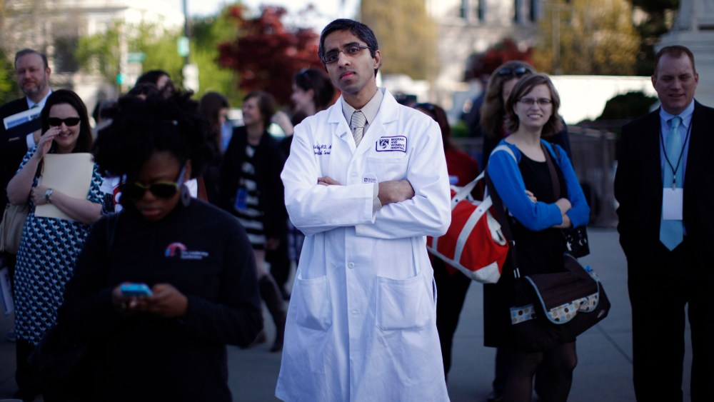 Doctor Vivek Murthy stands among other bystanders outside the Supreme Court in Washington, March 26, 2012.