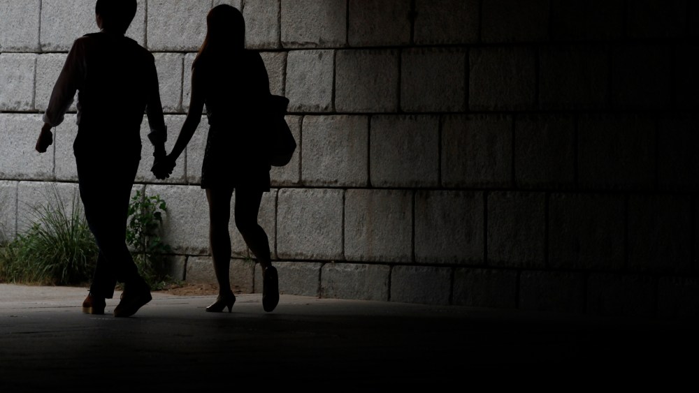 A young couple walks while holding hands under a bridge in central Seoul, South Korea. (Photo by Lee Jae Won/Reuters)