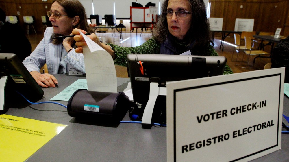 Election judges Jillian Alderbron (R) and Ruth Noel (L) prepare their voter check-in stations at an early voting polling station in Silver Spring, Md., Oct. 27, 2012. (Photo by Gary Cameron/Reuters)