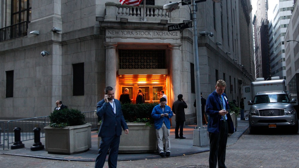 Traders stand outside the New York Stock Exchange prior to the opening bell.