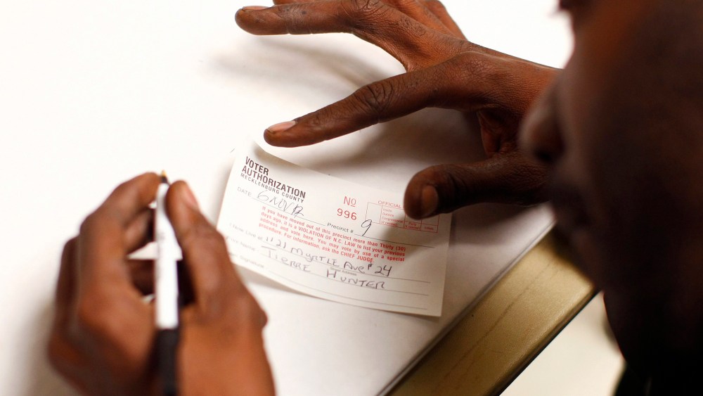 A man fills out a voter authorization form as he arrives to vote in Charlotte, North Carolina, Nov. 6, 2012.