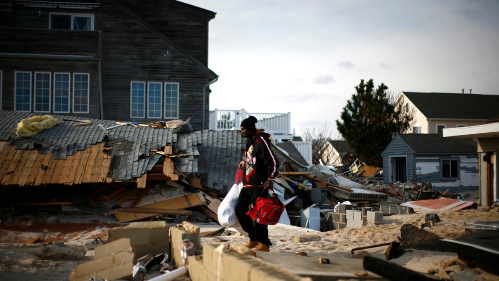 A man looks through homes damaged by Hurricane Sandy in Ortley Beach, New Jersey