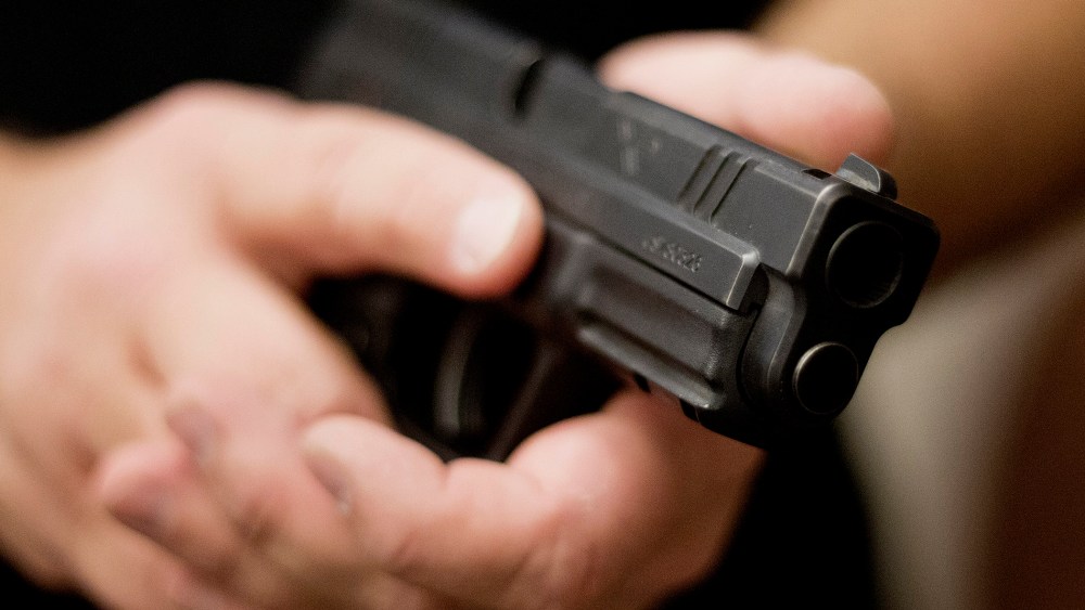 A firearms instructor holds a handgun.