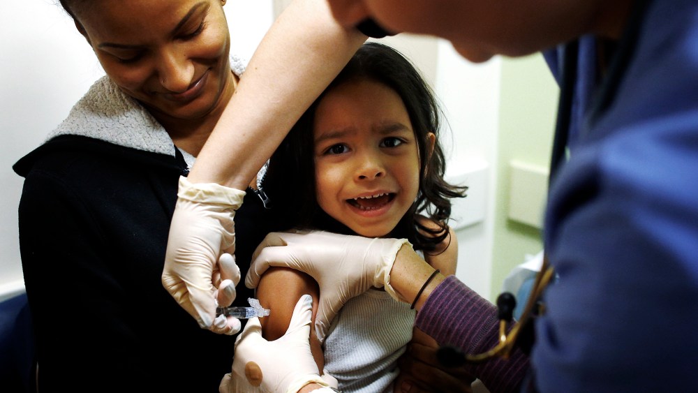 Mercado sits in his mother's lap while getting an influenza vaccine at Boston Children's Hospital in Boston