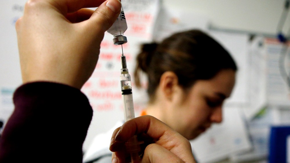 Nurses prepare influenza vaccine injections during a flu shot clinic in Boston