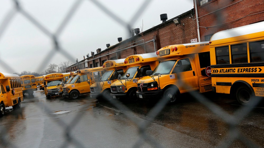 School buses are seen parked behind a locked bus depot fence in the Queens borough of New York Jan. 16, 2013. (Photo by Shannon Stapleton/Reuters)