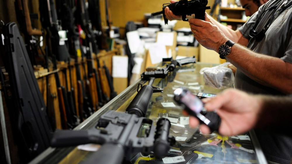 Customers look over the last two AR-15 style rifles for sale inside the Bullet Hole gun shop in Sarasota, Fla., Jan. 16, 2013.