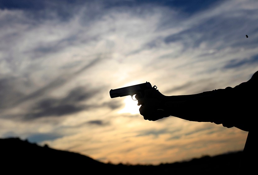 A man fires his handgun along a mountain range in Buckeye, Arizona January 20, 2013. (Photo by Joshua Lott/Reuters)