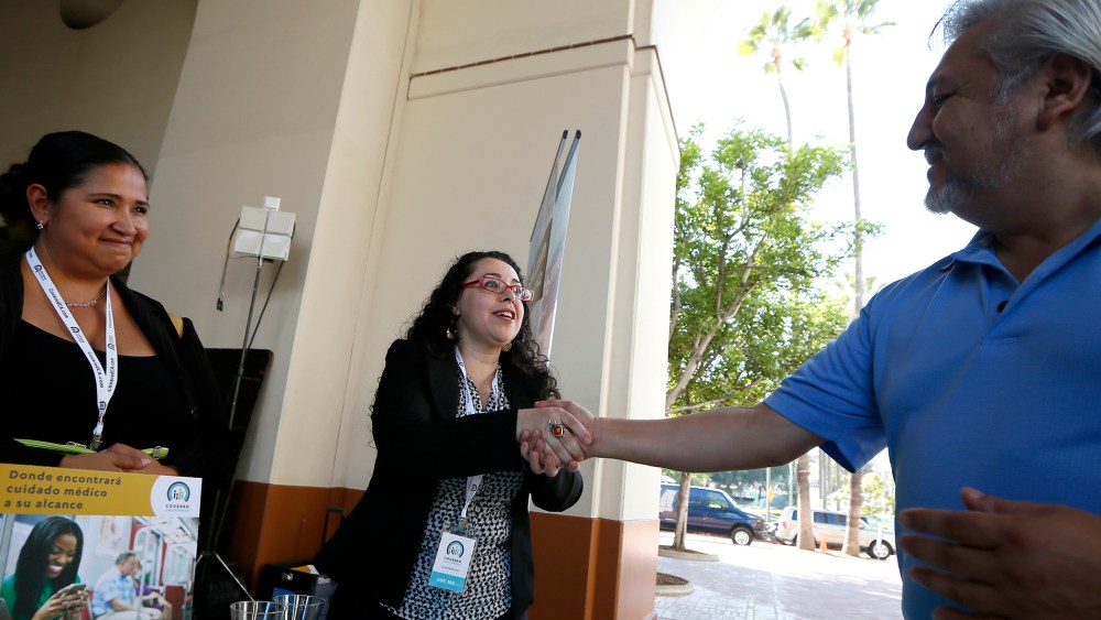 People sign up for health insurance information at a Covered California event in Los Angeles