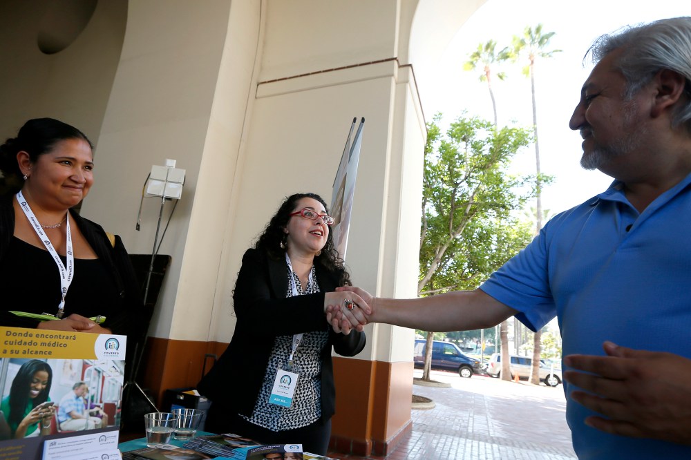 People sign up for health insurance information at a Covered California event in Los Angeles
