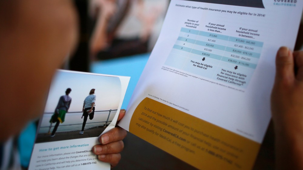 A potential insurance customer browses leaflets at a "Covered California" event in Los Angeles on Oct. 1, 2013.