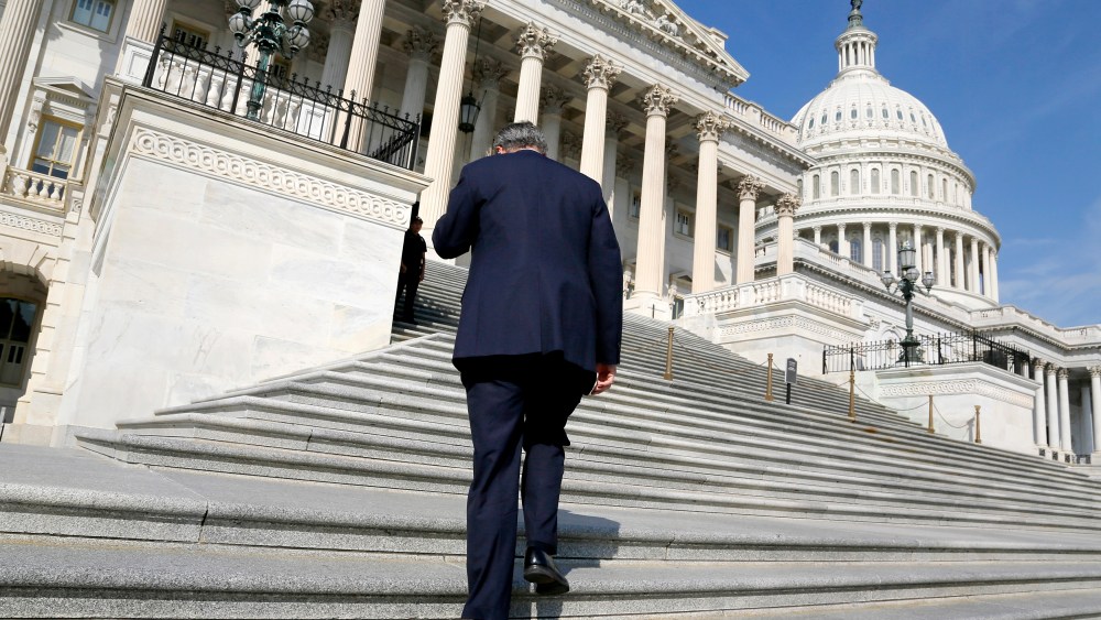 A member of the U.S. House of Representatives talks on the phone as he arrives for a vote at the U.S. Capitol in Washington October 5, 2013.