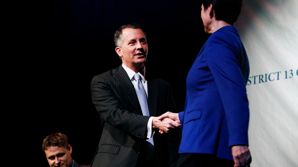 Democrat Alex Sink (C) and Republican David Jolly, both candidates for Florida's congressional District 13, shake hands before participating in a candidate forum in Clearwater, Florida, February 25, 2014.