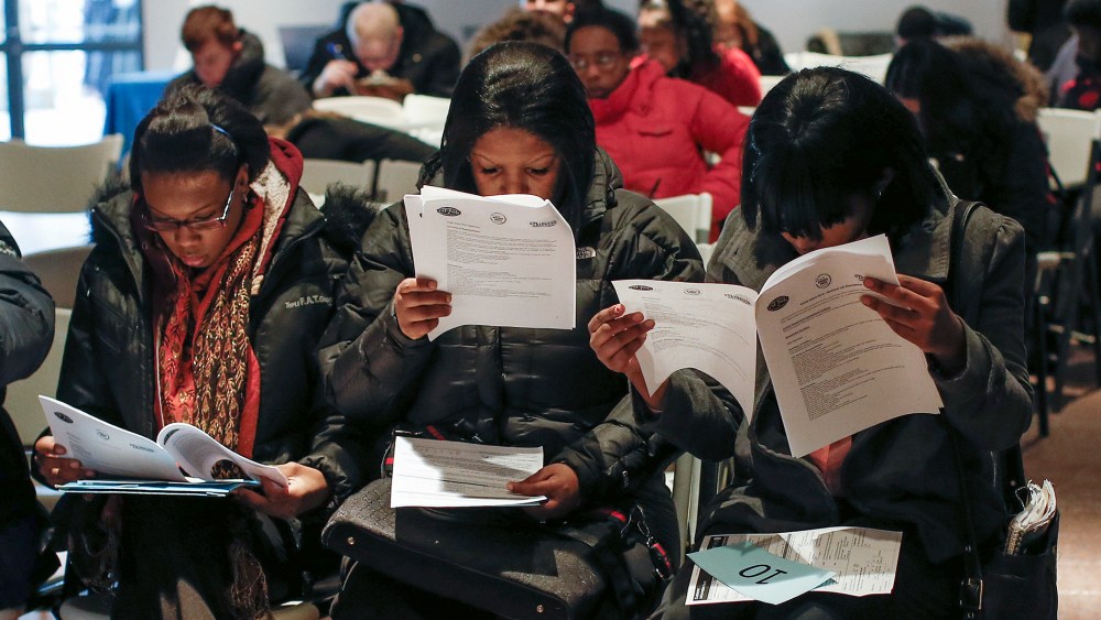 People fill out application forms before a screening session for seasonal jobs at Coney Island in the Brooklyn borough of New York on March 4, 2014.