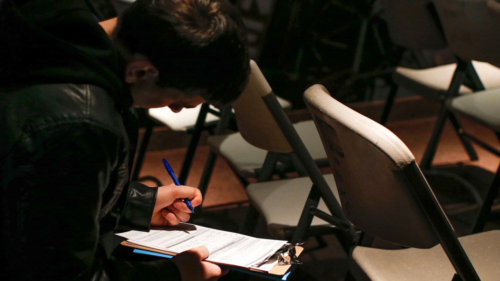 A man fills out paperwork before a screening session for seasonal jobs at Coney Island, March 4, 2014, in Brooklyn, NY.