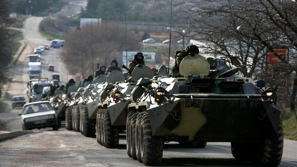 Soldiers, believed to be Russian, ride on military armored personnel carriers on a road near the Crimean port city of Sevastopol on March 10, 2014.