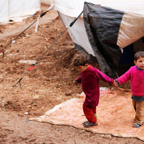 Syrian refugee children walk through mud at the Bab Al-Salam refugee camp in Azaz, near the Syrian-Turkish border, March 14, 2014.