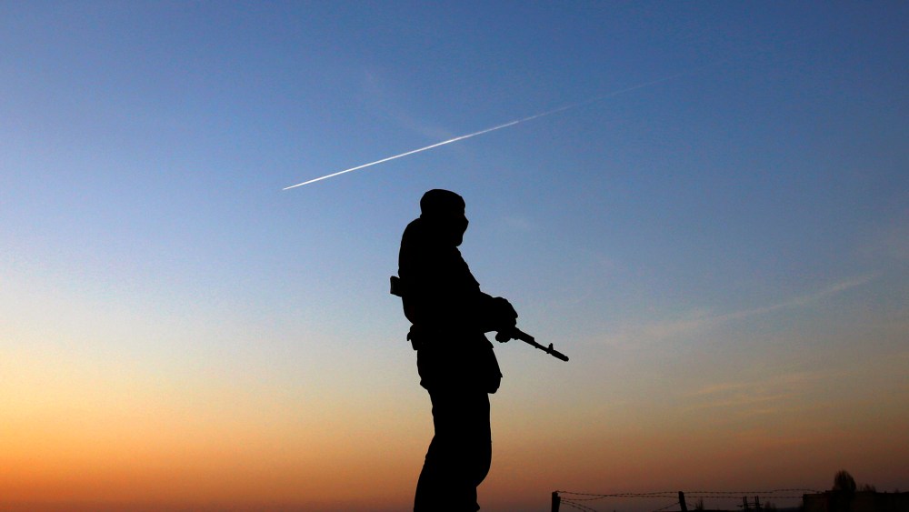 A Ukrainian soldier stands guard at a military camp the Ukrainian Army forces set up close to the Russian border, March 21, 2014, in east Ukraine.
